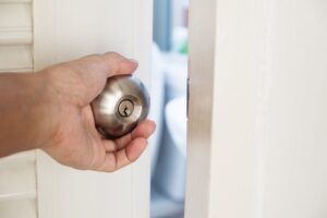 Close-up-hand-holding-door-knob,-opening-door-slightly,-selective-focus-cm