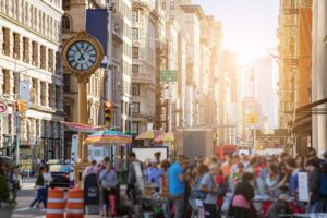 Sunlight shines on the buildings of Manhattan with crowds of people in New York City-cm