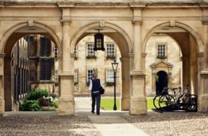 Student-passing-through-a-college-campus-in-Cambridge-Universitiy-cm