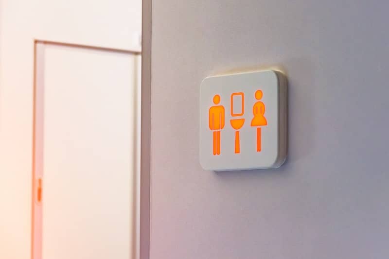 The busy toilet sign is marked in red, against the background is a door from the wc inside the plane.-cm
