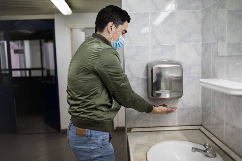 Man dries wet hands with an electric hand dryers-cm