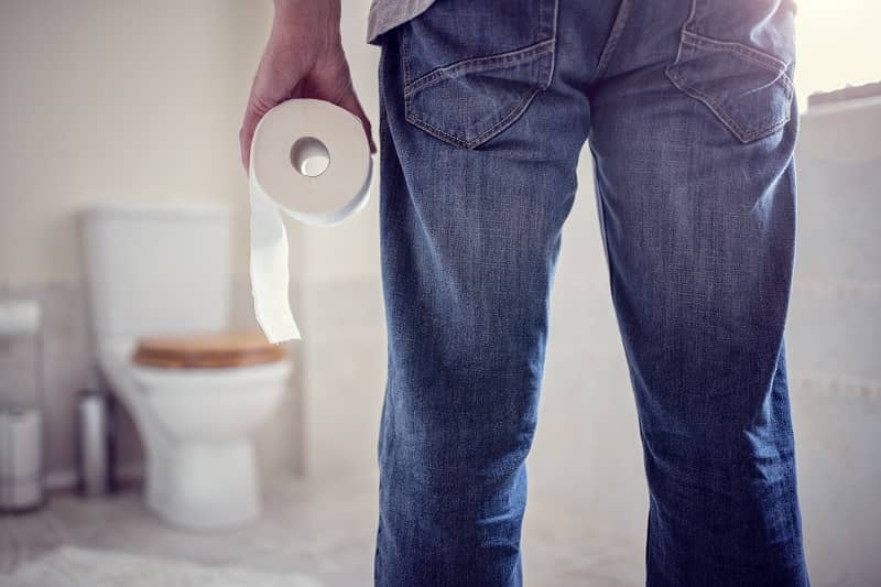 Man holding toilet paper roll in bathroom-cm