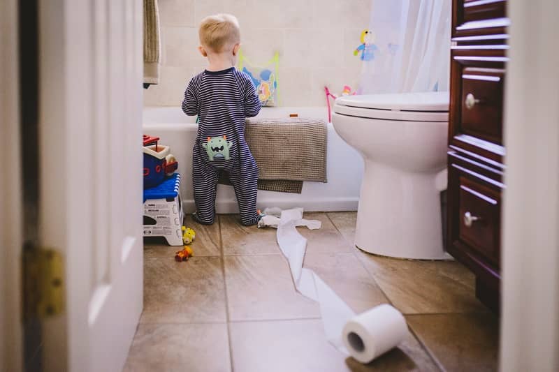 Baby playing with toilet paper in bathroom-cm