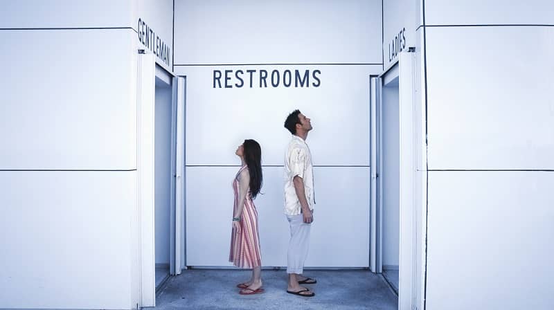 Confused Couple Looking Up at Restroom Signs-cm