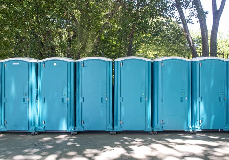 A row of portable toilets in a city mall. -cm