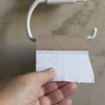 A hand taking the last toilet paper towel -cm